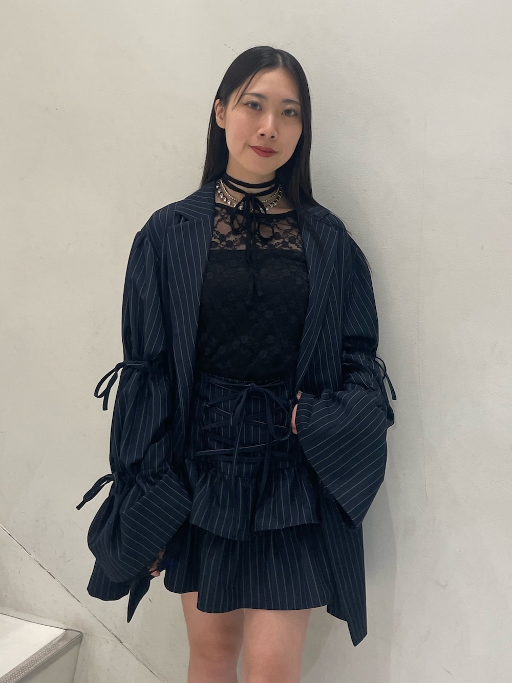 ブラック系のTシャツ/カットソー、ブルー系のテーラードジャケット、ブルー系のスカートを着用したレディースの秋コーディネートの5枚目の写真