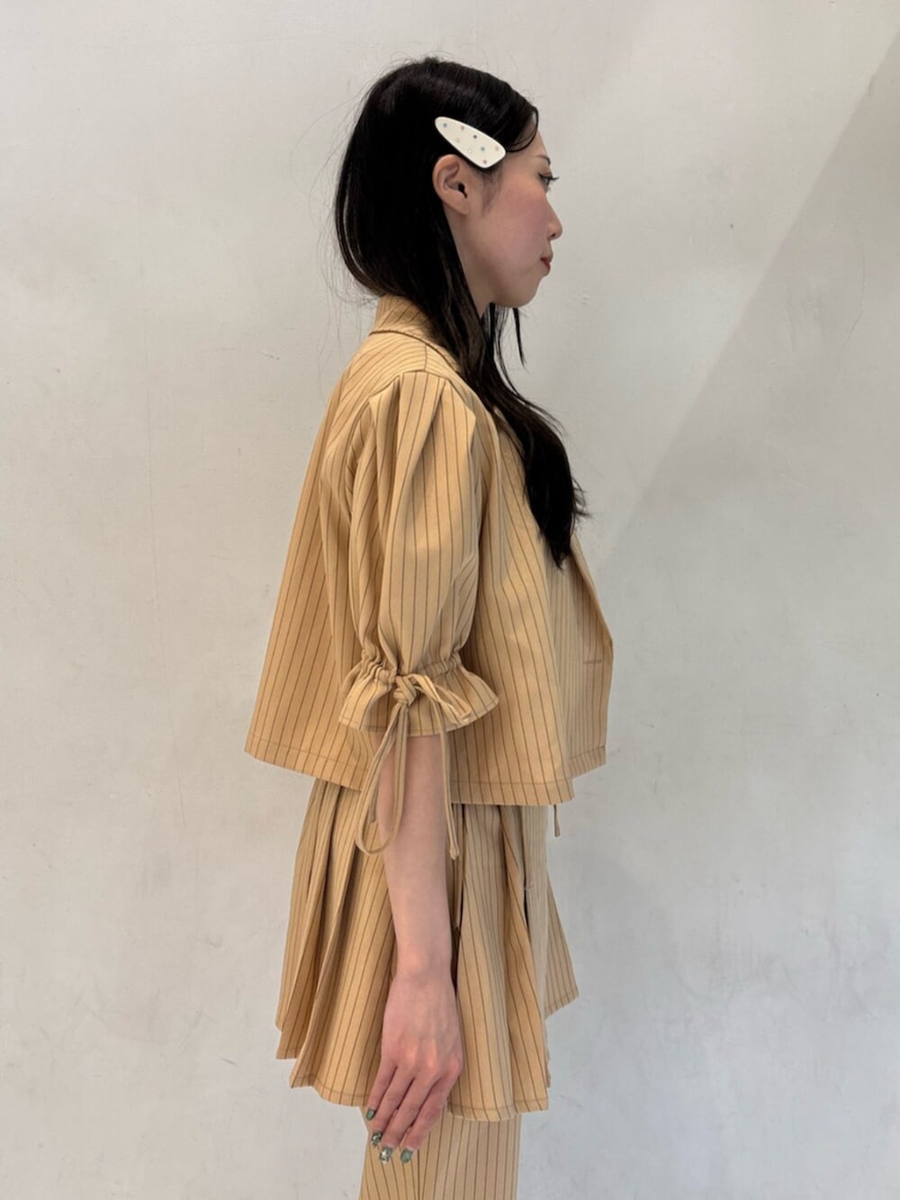 ベージュ系のテーラードジャケット、ベージュ系のその他パンツ、ベージュ系のスカートを着用したレディースの冬コーディネートの7枚目の写真