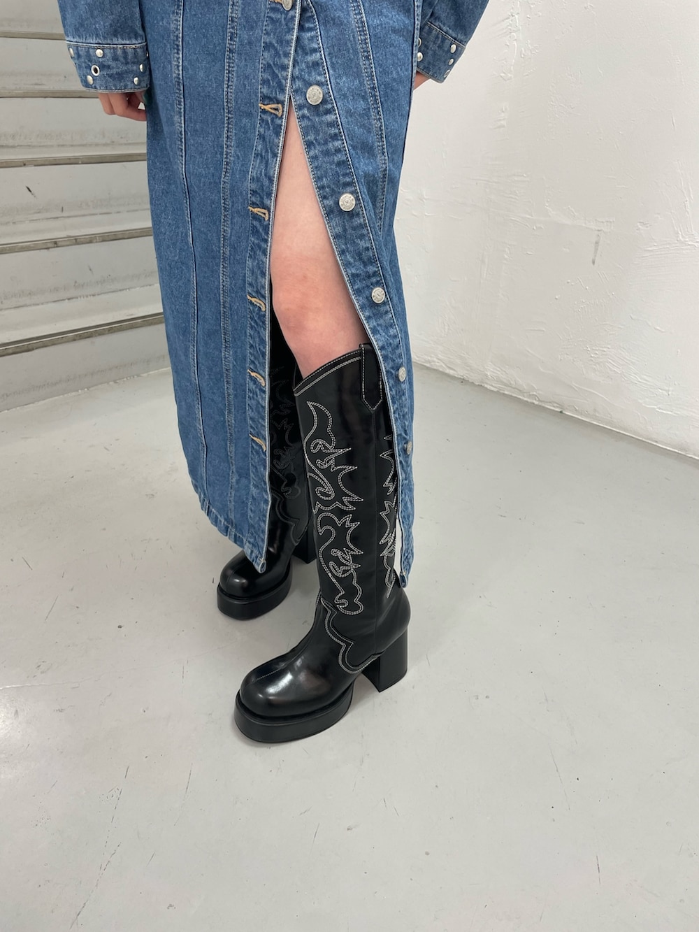 ブルー系のワンピース、ブラック系のブーツ、ブルー系のネクタイを着用したレディースの冬コーディネートの8枚目の写真