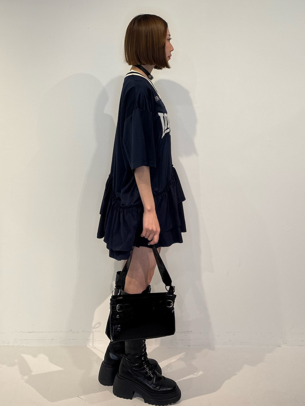 ブルー系のワンピース、ブラック系のハンドバッグ、ブラック系のブーツを着用したレディースの冬コーディネートの3枚目の写真