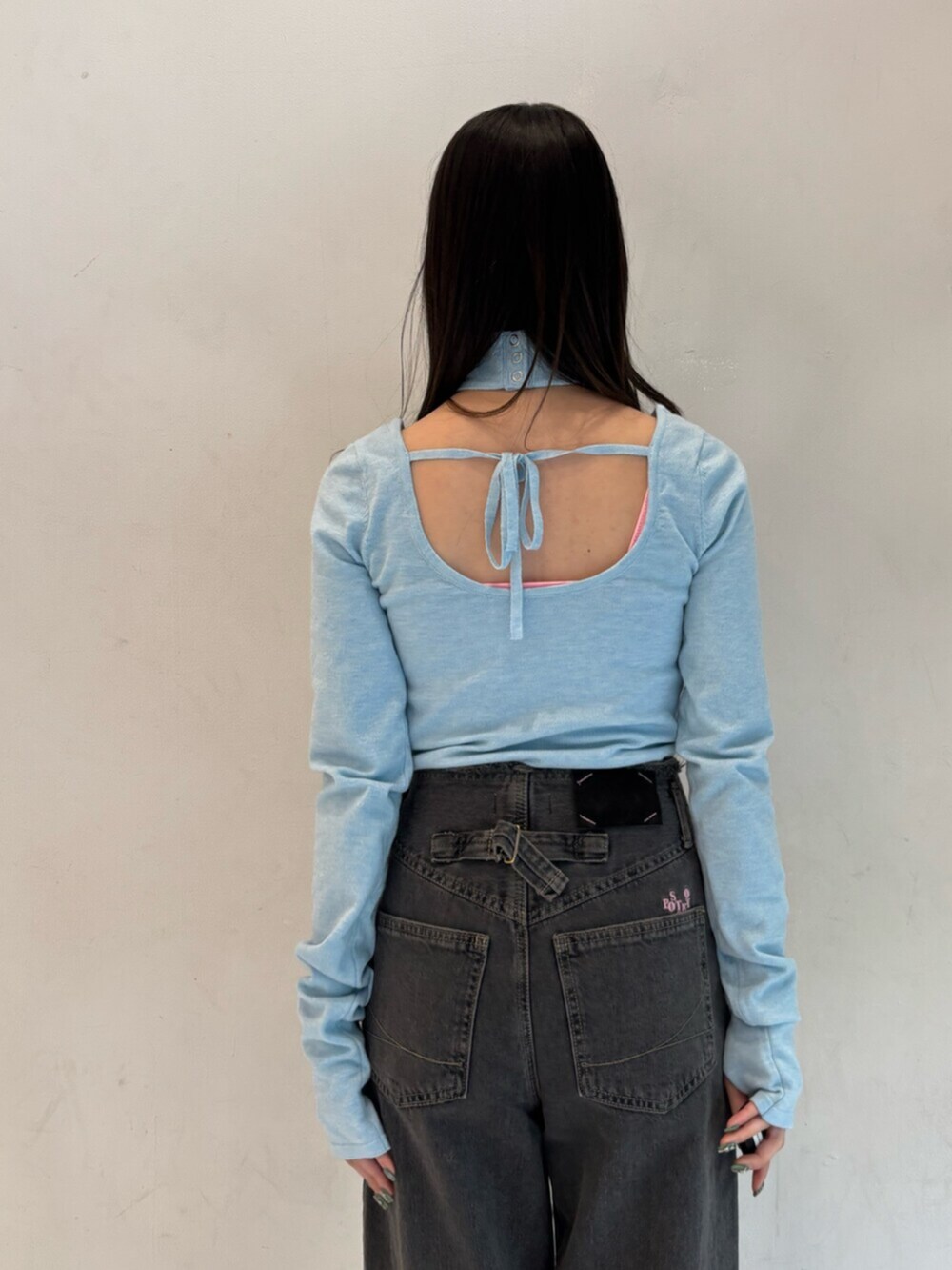 ブラック系のデニムパンツ、ブルー系のニット/セーター、シルバー系のメガネを着用したレディースの冬コーディネートの7枚目の写真