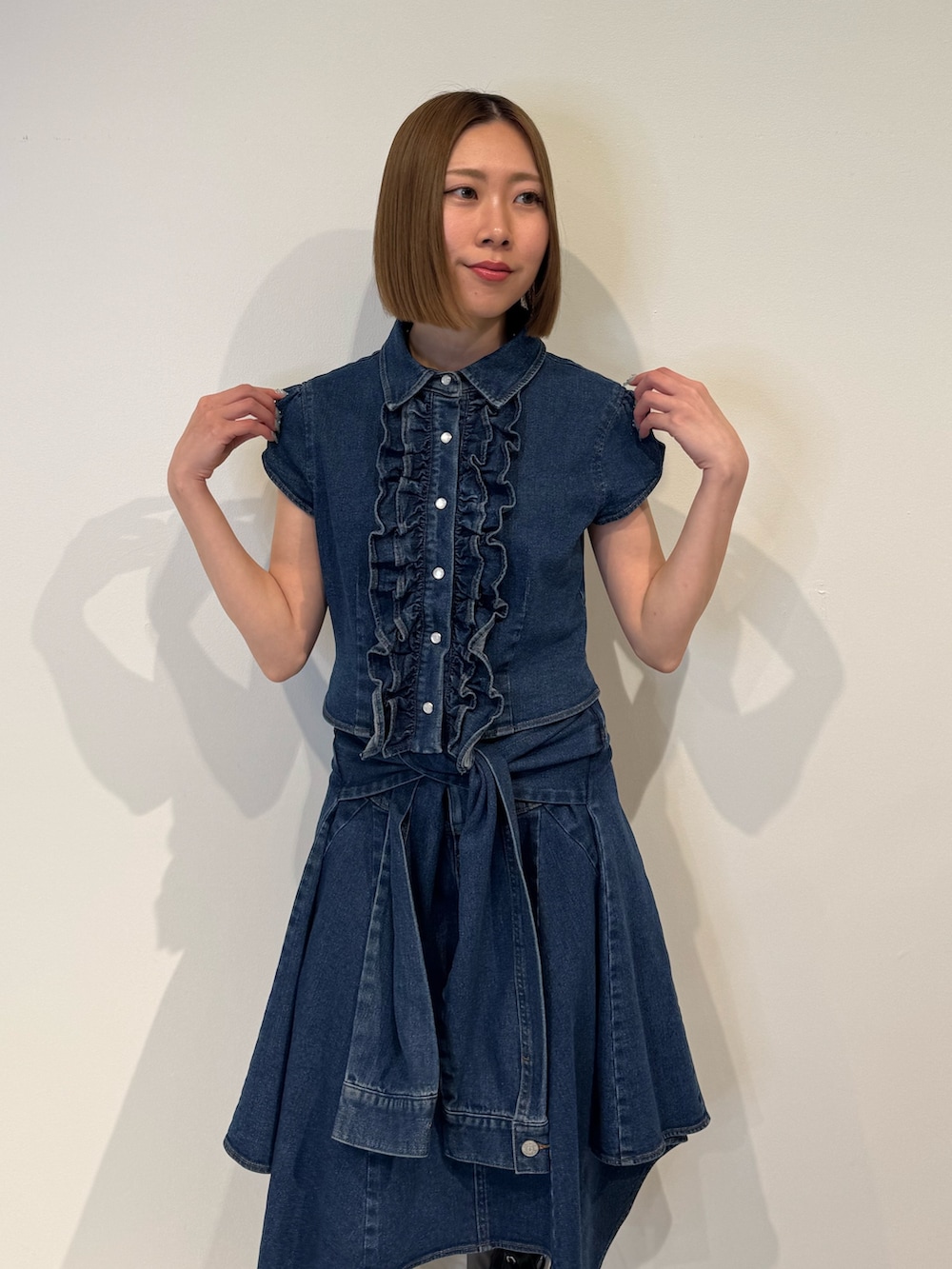 ブルー系のシャツ/ブラウス、ブルー系のスカート、ブラック系のブーツを着用したレディースの春コーディネートの6枚目の写真