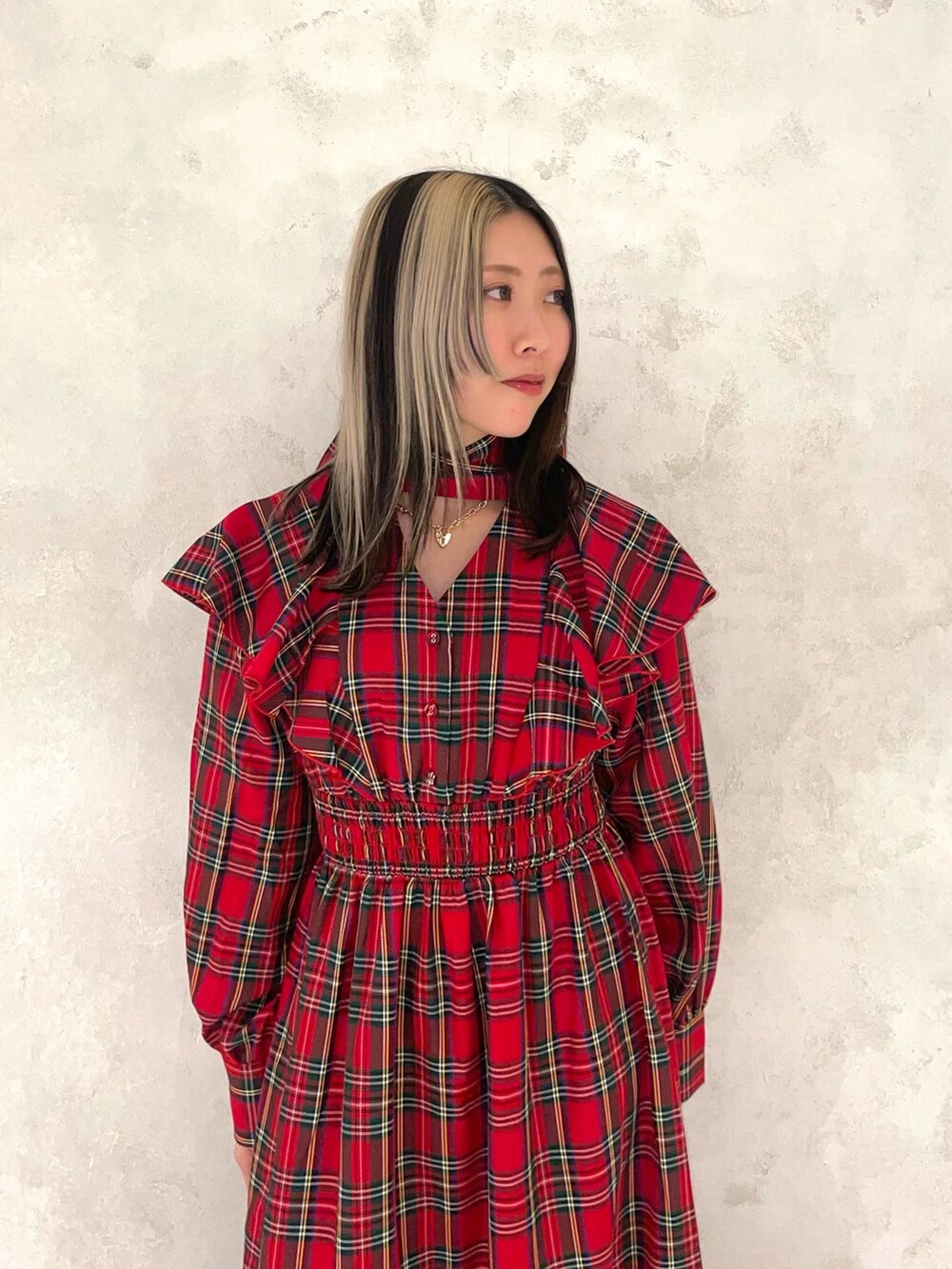 レッド系のワンピース、ゴールド系のネックレスを着用したレディースの冬コーディネートの4枚目の写真