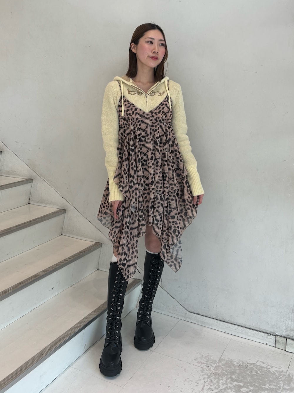 ブラウン系のワンピース、イエロー系のパーカー、ブラック系のブーツを着用したレディースの冬コーディネートの2枚目の写真