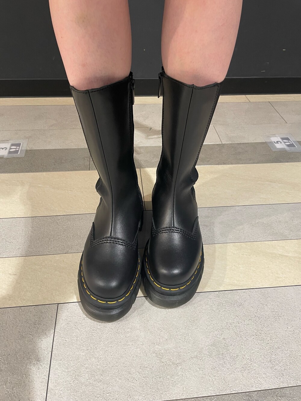 ホワイト系のTシャツ/カットソー、グリーン系のスカート、ブルー系のライダースジャケットを着用したレディースの秋コーディネートの8枚目の写真