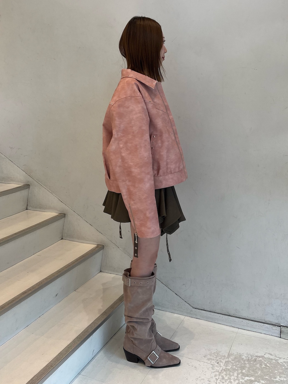 ベージュ系のスカート、ピンク系のブーツ、ピンク系のブルゾンを着用したレディースの冬コーディネートの3枚目の写真