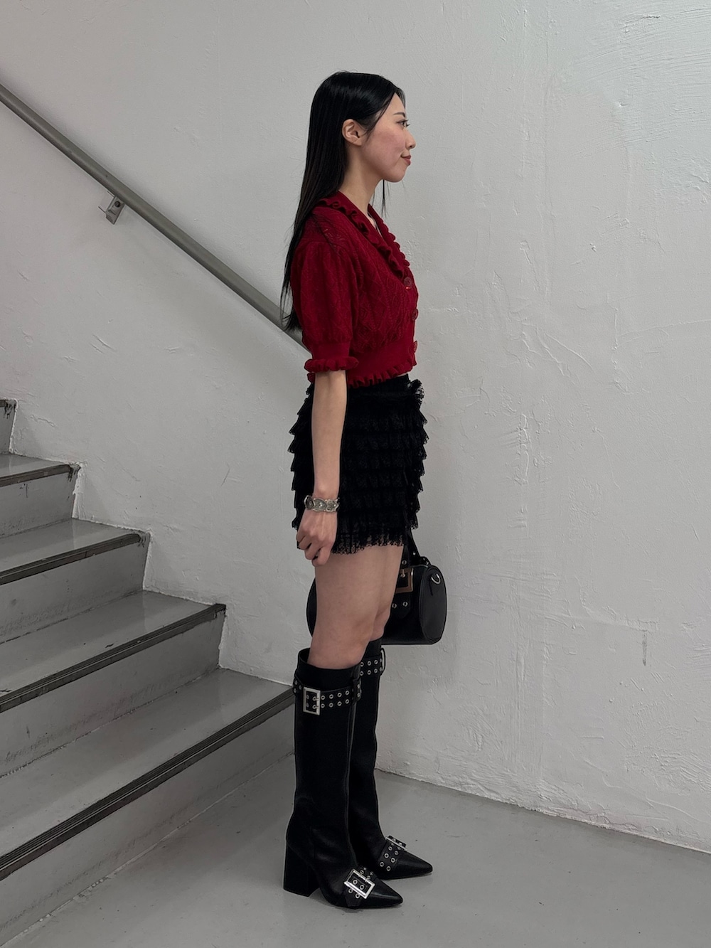 ブラック系のブーツ、ブラック系のボストンバッグ、ブラック系のその他パンツを着用したレディースの春コーディネートの4枚目の写真