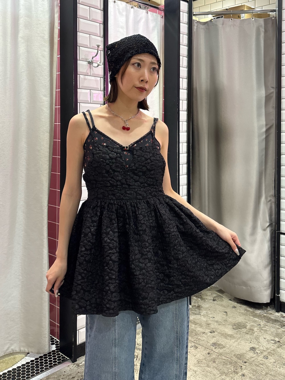 ブルー系のデニムパンツ、ブラック系のチュニック、レッド系のネックレスを着用したレディースの夏コーディネートの6枚目の写真