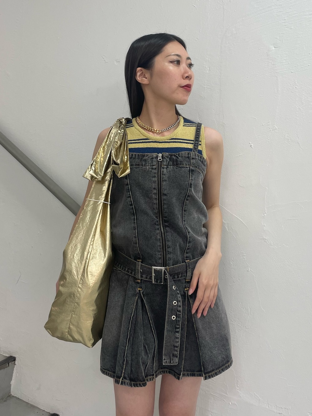 ブラック系のワンピース、イエロー系のタンクトップ、ゴールド系のトートバッグを着用したレディースの夏コーディネートの4枚目の写真