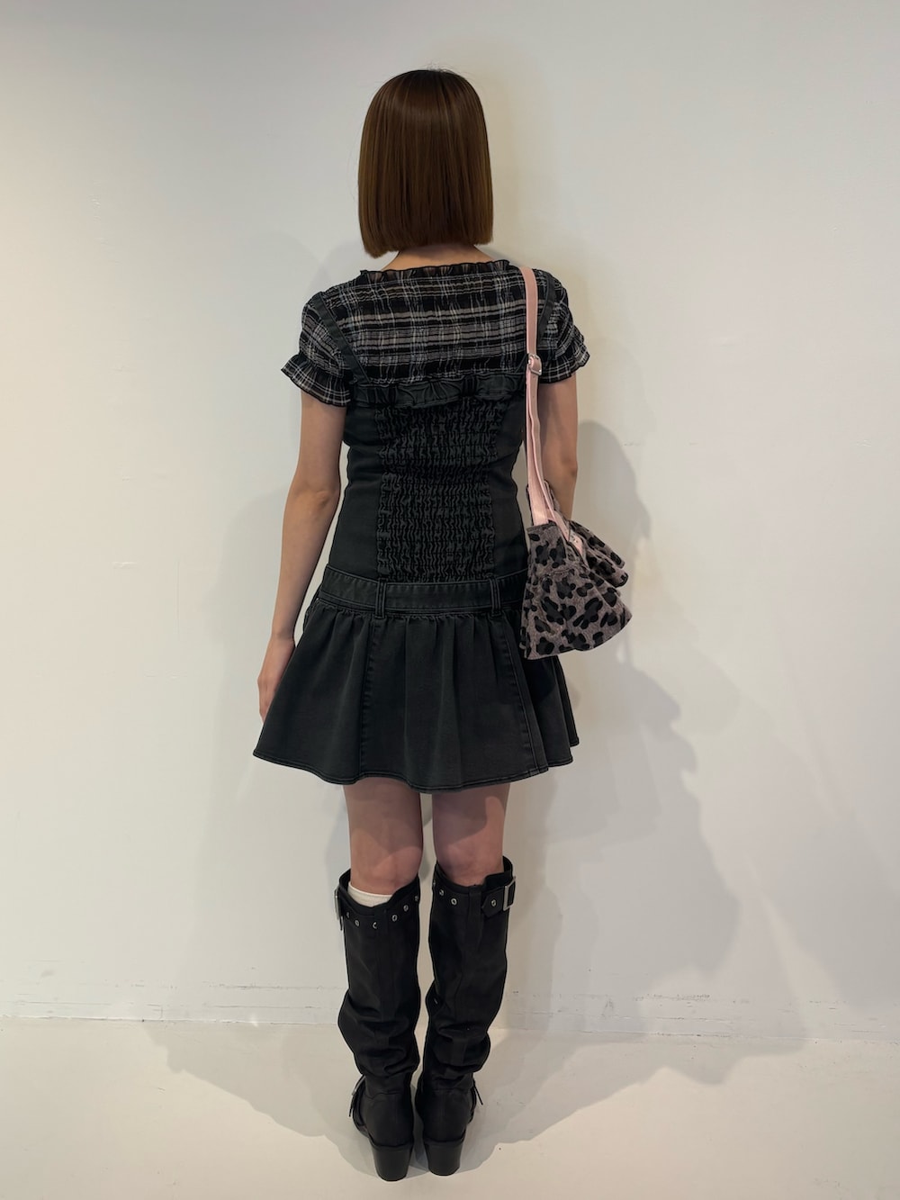 ブラック系のブーツ、ブラック系のワンピース、ブラック系のTシャツ/カットソーを着用したレディースの春コーディネートの4枚目の写真