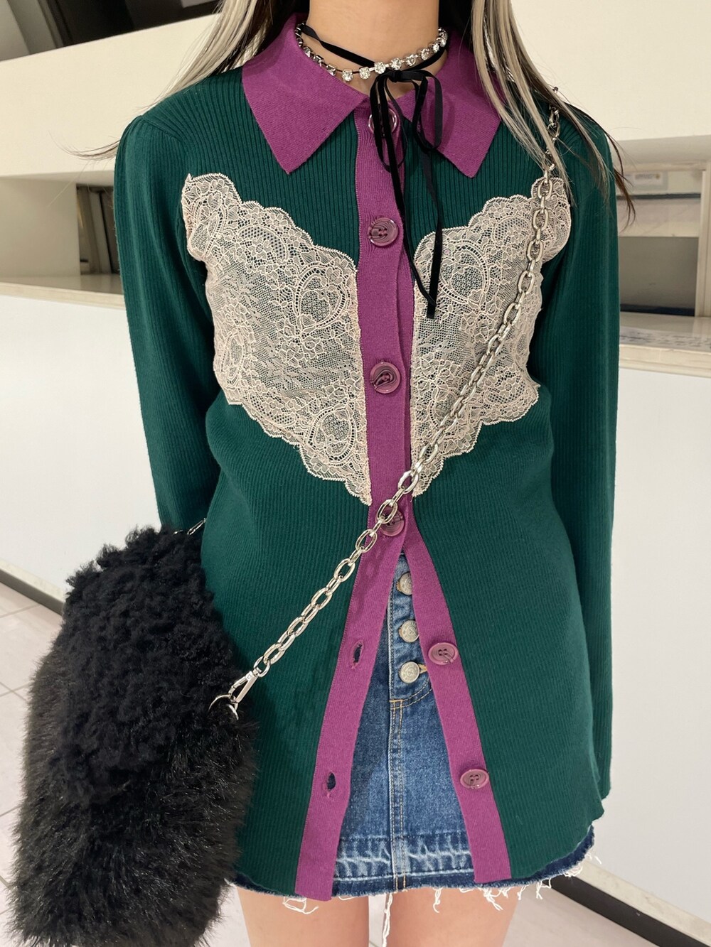 グリーン系のカーディガン/ボレロ、ブルー系のデニムパンツ、ブラック系のハンドバッグを着用したレディースの冬コーディネートの8枚目の写真