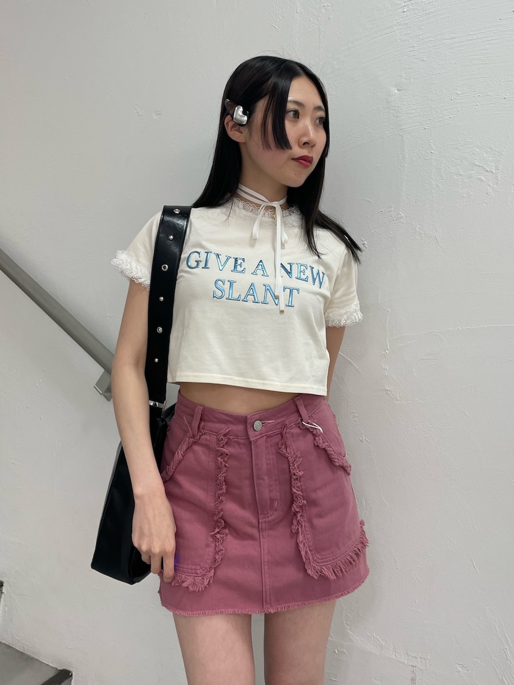 ピンク系のスカート、ホワイト系のTシャツ/カットソー、ブラック系のショルダーバッグを着用したレディースの春コーディネートの5枚目の写真