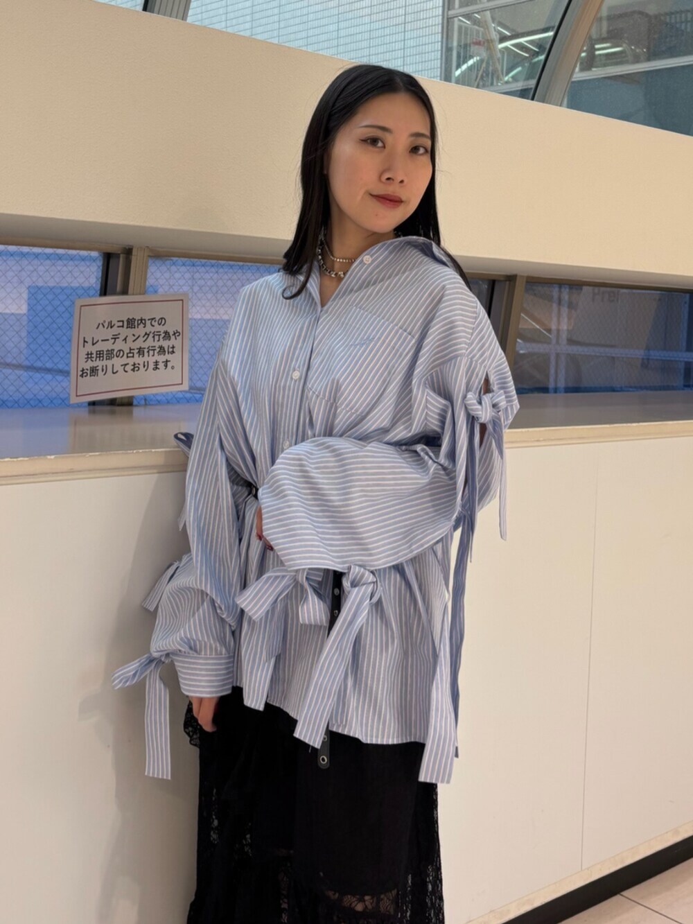 ブラック系のスカート、ブルー系のシャツ/ブラウス、ブラック系のパンプスを着用したレディースの冬コーディネートの7枚目の写真