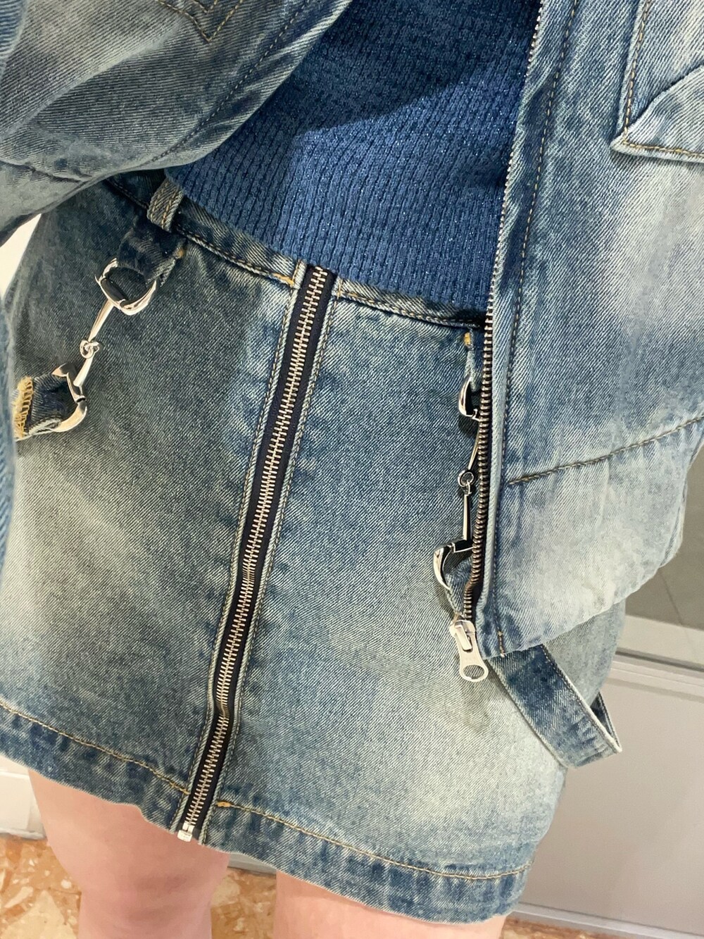 ブルー系のデニムスカート、ブルー系のニット/セーター、ブルー系のデニムジャケットを着用したレディースの冬コーディネートの8枚目の写真