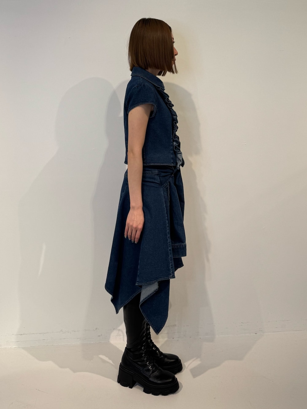 ブルー系のシャツ/ブラウス、ブルー系のスカート、ブラック系のブーツを着用したレディースの春コーディネートの3枚目の写真