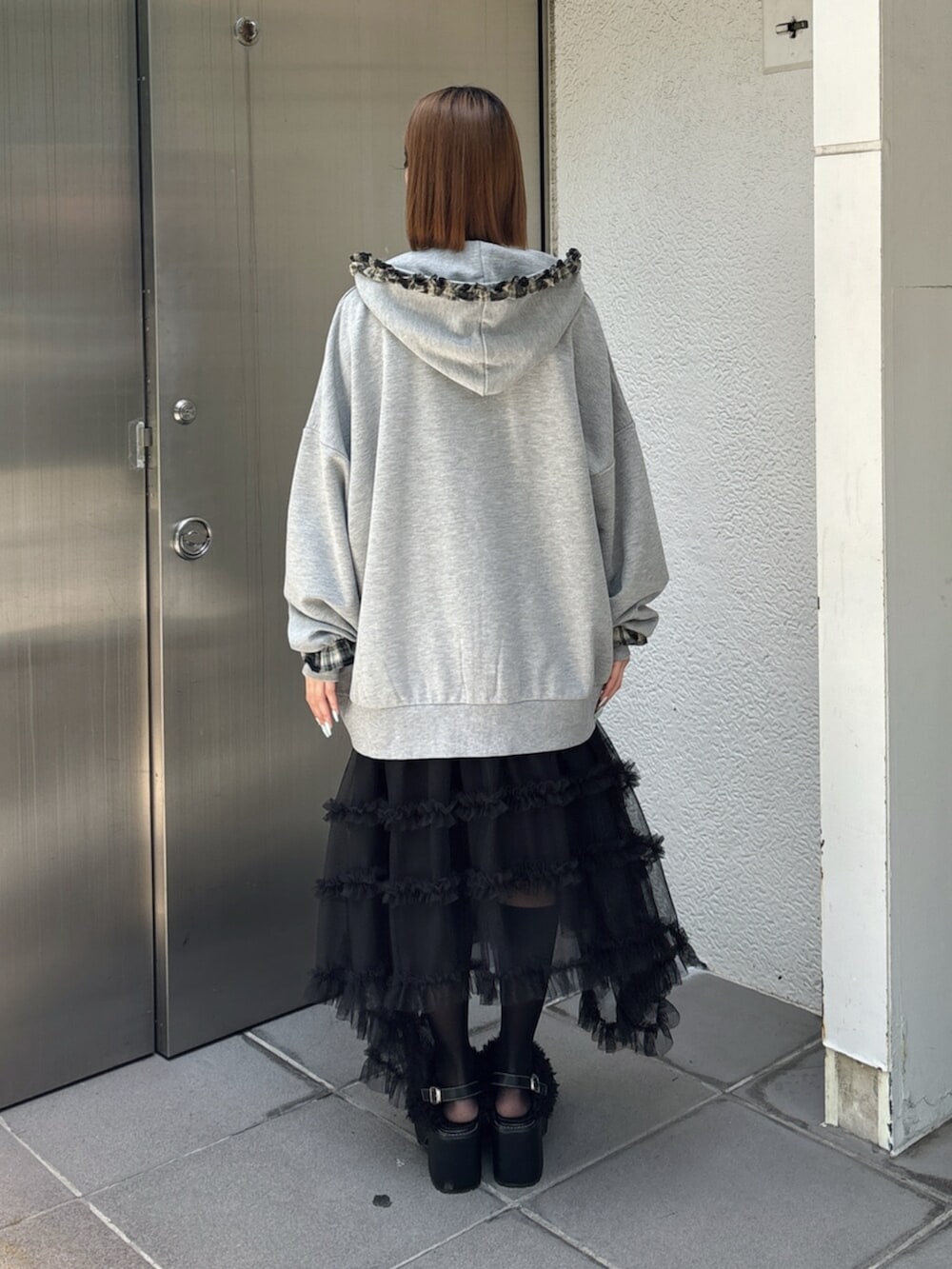 グレー系のその他トップス、ブラック系のスカート、ブラック系のサンダルを着用したレディースの夏コーディネートの4枚目の写真
