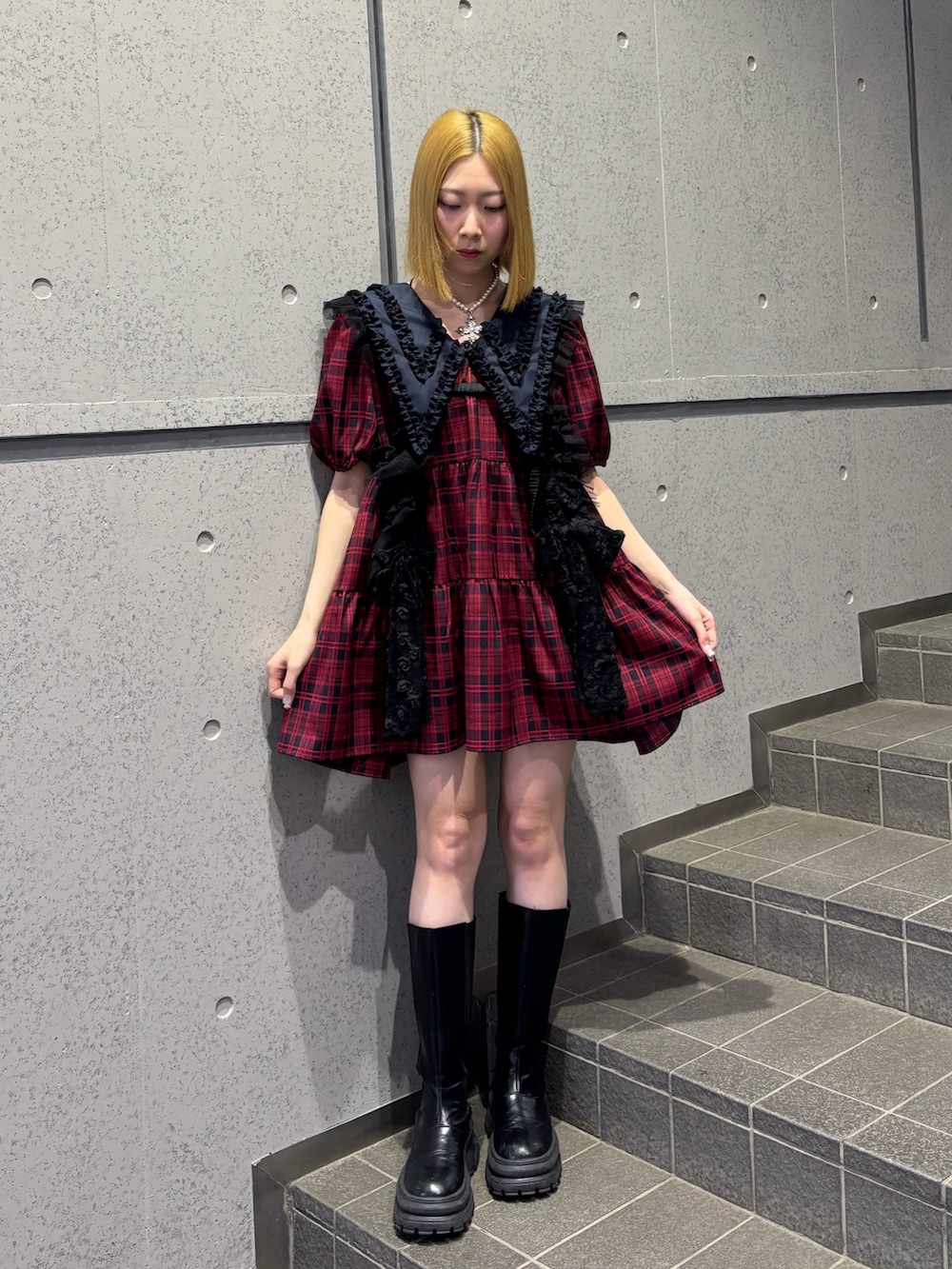 レッド系のワンピース、ブラック系のベルトを着用したレディースの春コーディネートの2枚目の写真