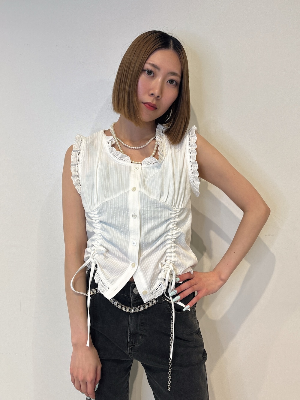 ホワイト系のシャツ/ブラウス、ブラック系のデニムパンツ、シルバー系のベルトを着用したレディースの夏コーディネートの5枚目の写真