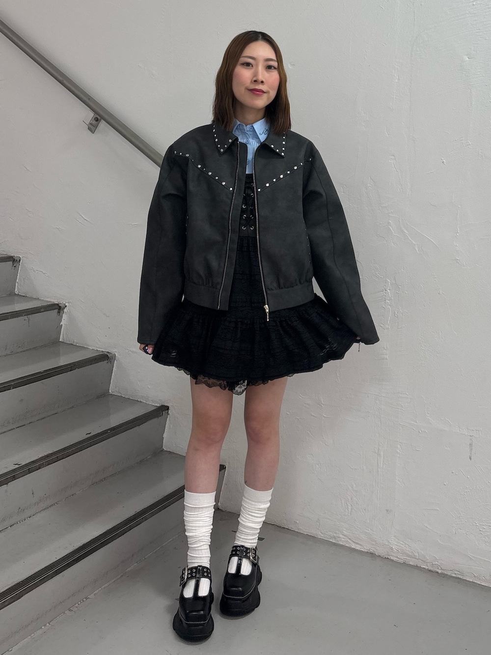 ブラック系のワンピース、ブルー系のシャツ/ブラウス、ブラック系のブルゾンを着用したレディースの冬コーディネートの3枚目の写真