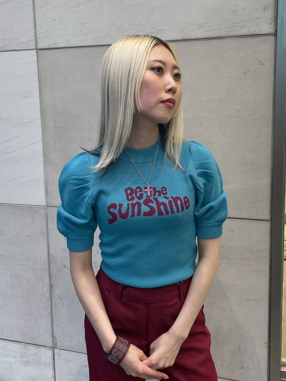 ブルー系のニット/セーター、レッド系のその他パンツ、レッド系のブレスレットを着用したレディースの夏コーディネートの5枚目の写真