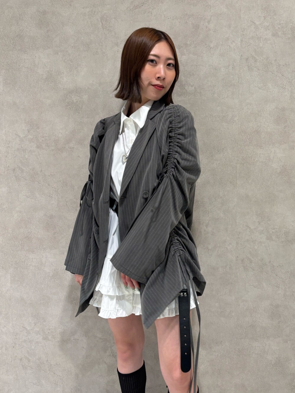 ホワイト系のワンピース、ブラック系のパンプス、グレー系のテーラードジャケットを着用したレディースの夏コーディネートの8枚目の写真