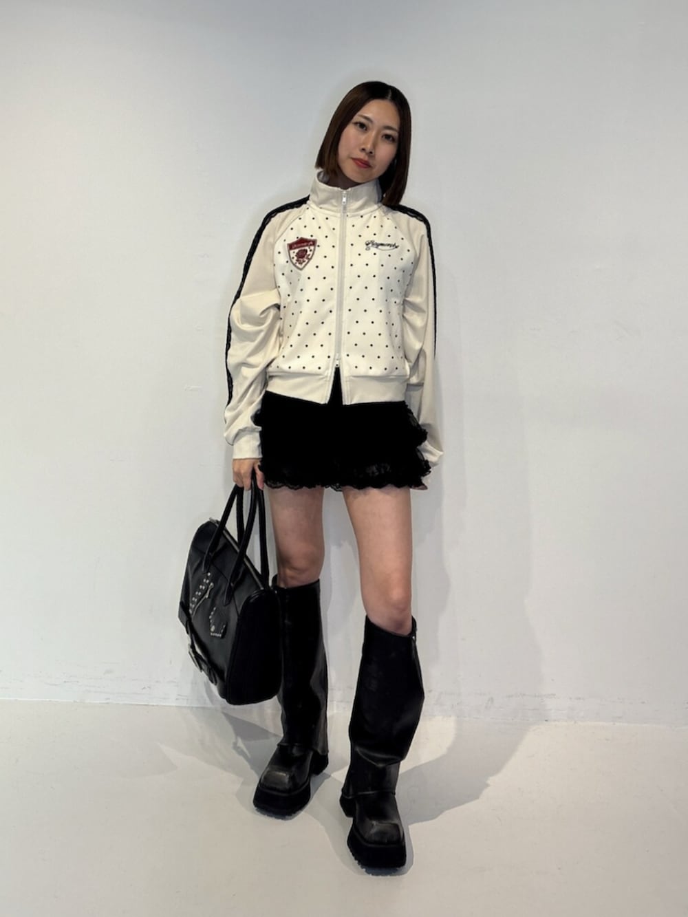 ブラック系のその他パンツ、ブラック系のブーツ、ブラック系のハンドバッグを着用したレディースの夏コーディネートの2枚目の写真
