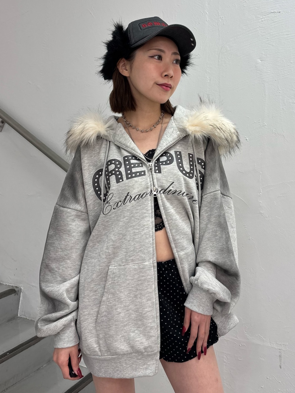 ブラック系のスカート、グレー系のパーカー、ブラック系のブーツを着用したレディースの冬コーディネートの7枚目の写真