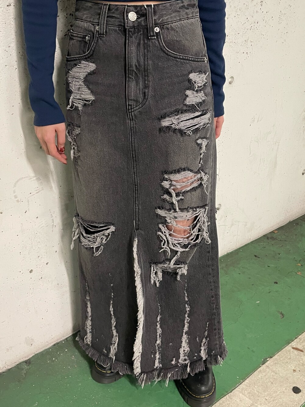 ブラック系のデニムスカート、ブラック系のTシャツ/カットソー、ブルー系のキャップを着用したレディースの冬コーディネートの8枚目の写真