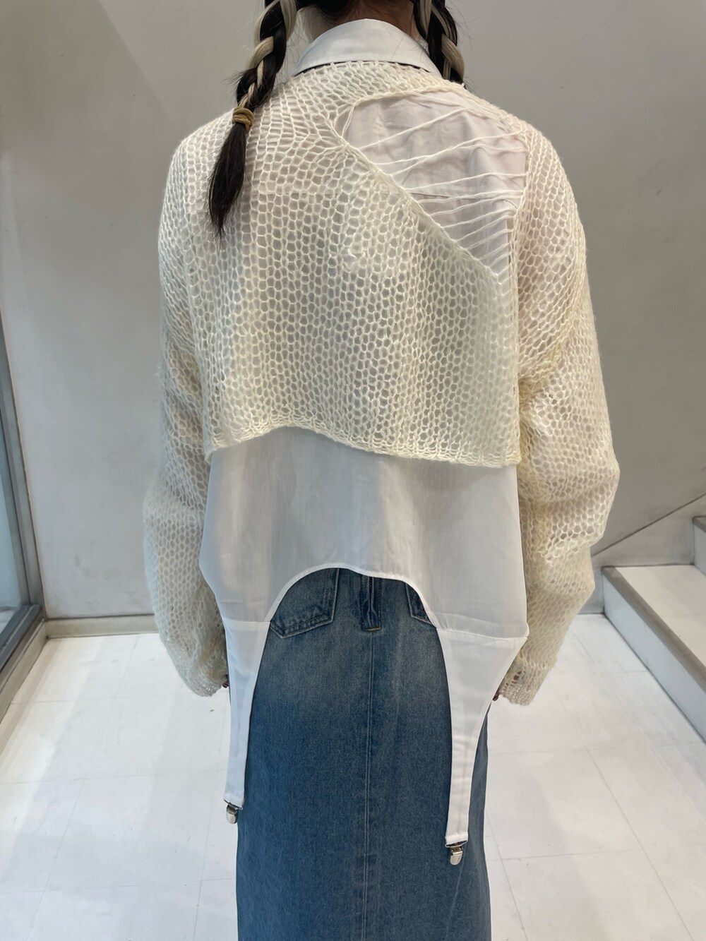 ホワイト系のニット/セーター、ホワイト系のシャツ/ブラウス、ブルー系のデニムパンツを着用したレディースの秋コーディネートの9枚目の写真