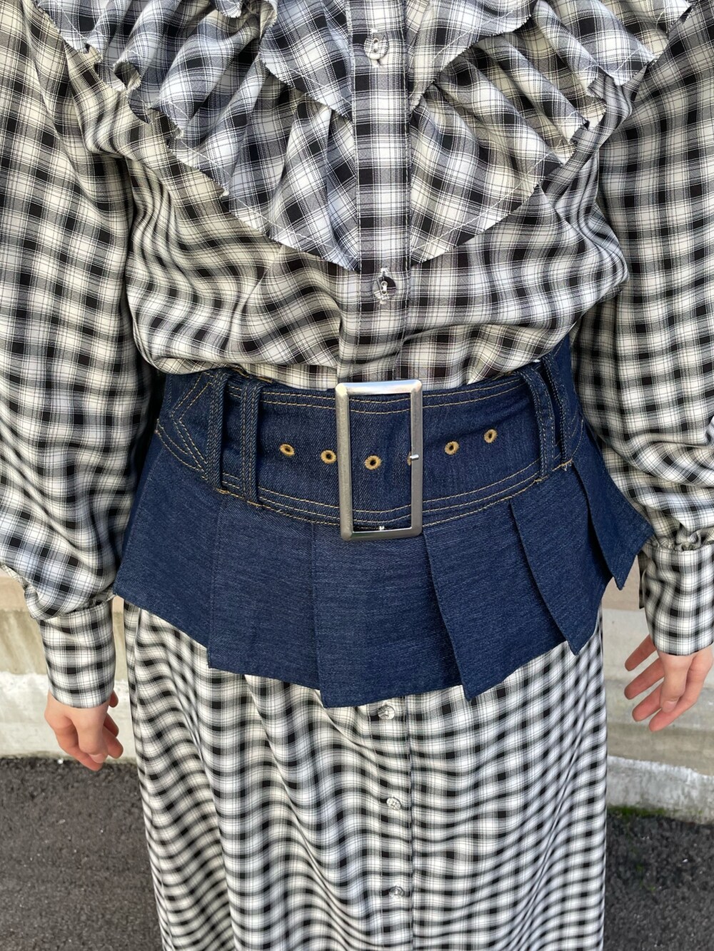 ブラック系のワンピース、ブルー系のベルト、シルバー系のネックレスを着用したレディースの春コーディネートの8枚目の写真