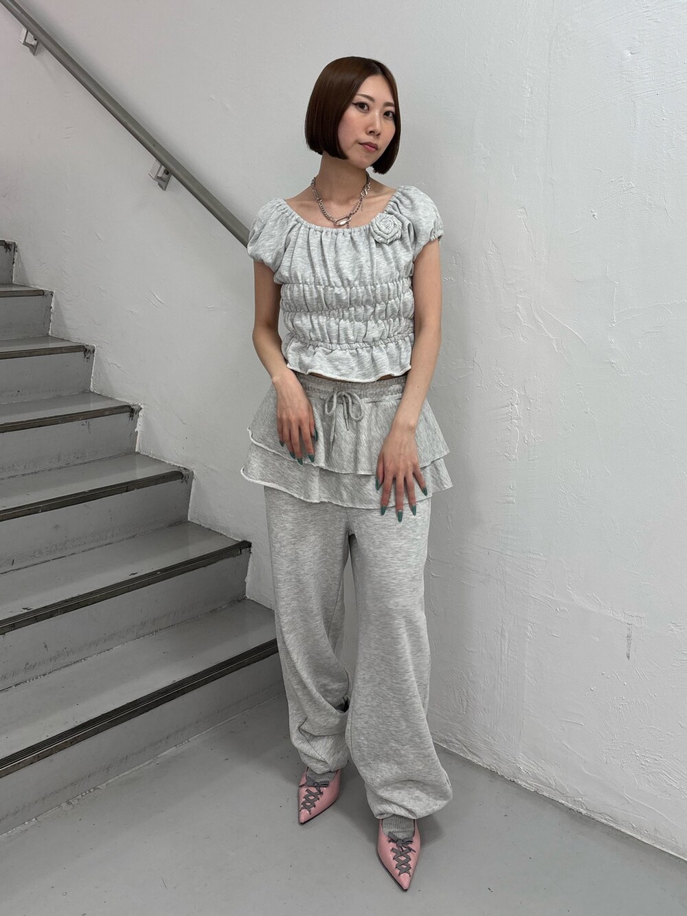 グレー系のスウェットパンツ、グレー系のTシャツ/カットソー、ピンク系のパンプスを着用したレディースの夏コーディネートの2枚目の写真