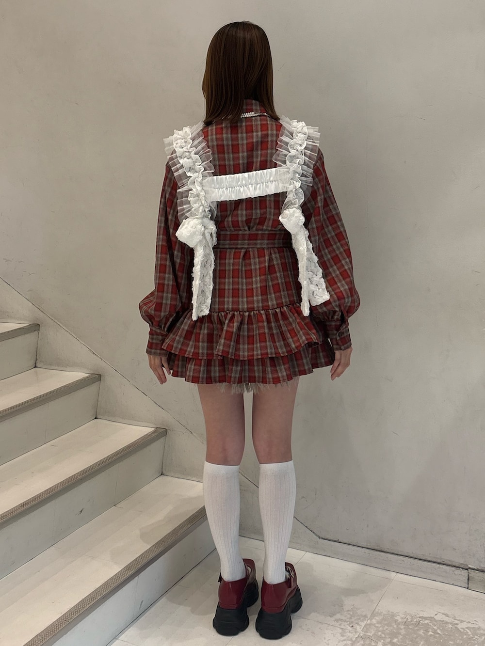 レッド系のワンピース、レッド系のローファー、ホワイト系のベルトを着用したレディースの冬コーディネートの4枚目の写真