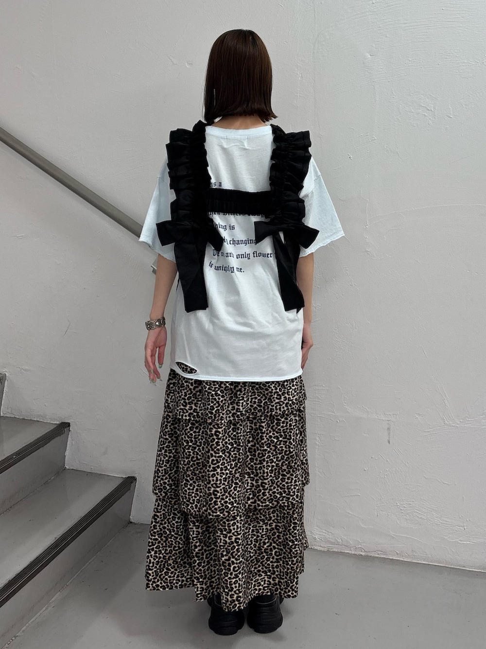 ブラウン系のスカート、ブルー系のTシャツ/カットソー、ブラック系のスニーカーを着用したレディースの夏コーディネートの4枚目の写真