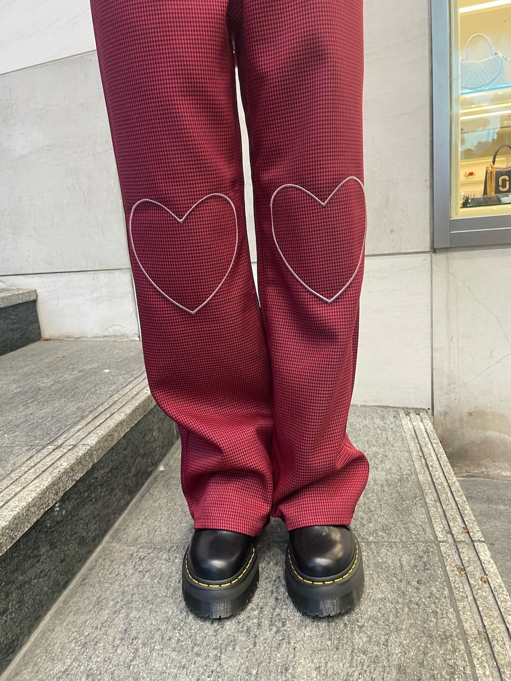 ブルー系のニット/セーター、レッド系のその他パンツ、レッド系のブレスレットを着用したレディースの夏コーディネートの8枚目の写真