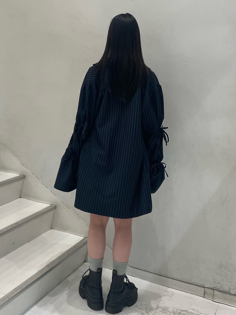 ブラック系のTシャツ/カットソー、ブルー系のテーラードジャケット、ブルー系のスカートを着用したレディースの秋コーディネートの4枚目の写真