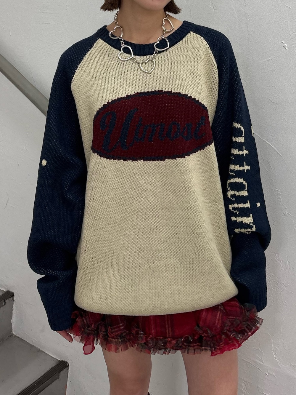 レッド系のブーツ、レッド系のスカート、ホワイト系のニット/セーターを着用したレディースの秋コーディネートの7枚目の写真