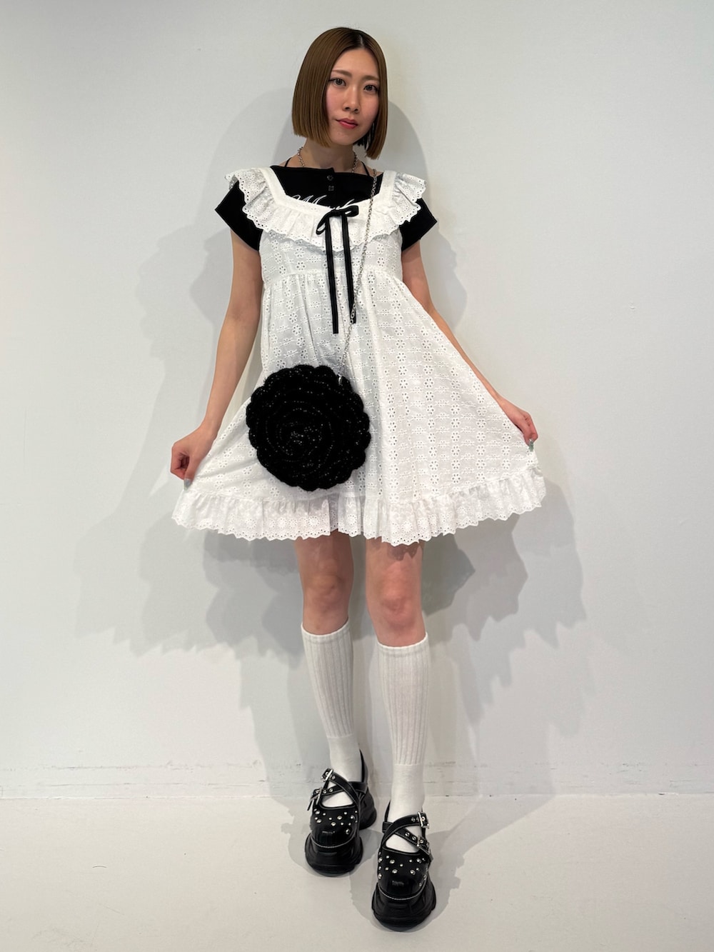 ホワイト系のワンピース、ブラック系のショルダーバッグ、ブラック系のTシャツ/カットソーを着用したレディースの春コーディネートの2枚目の写真