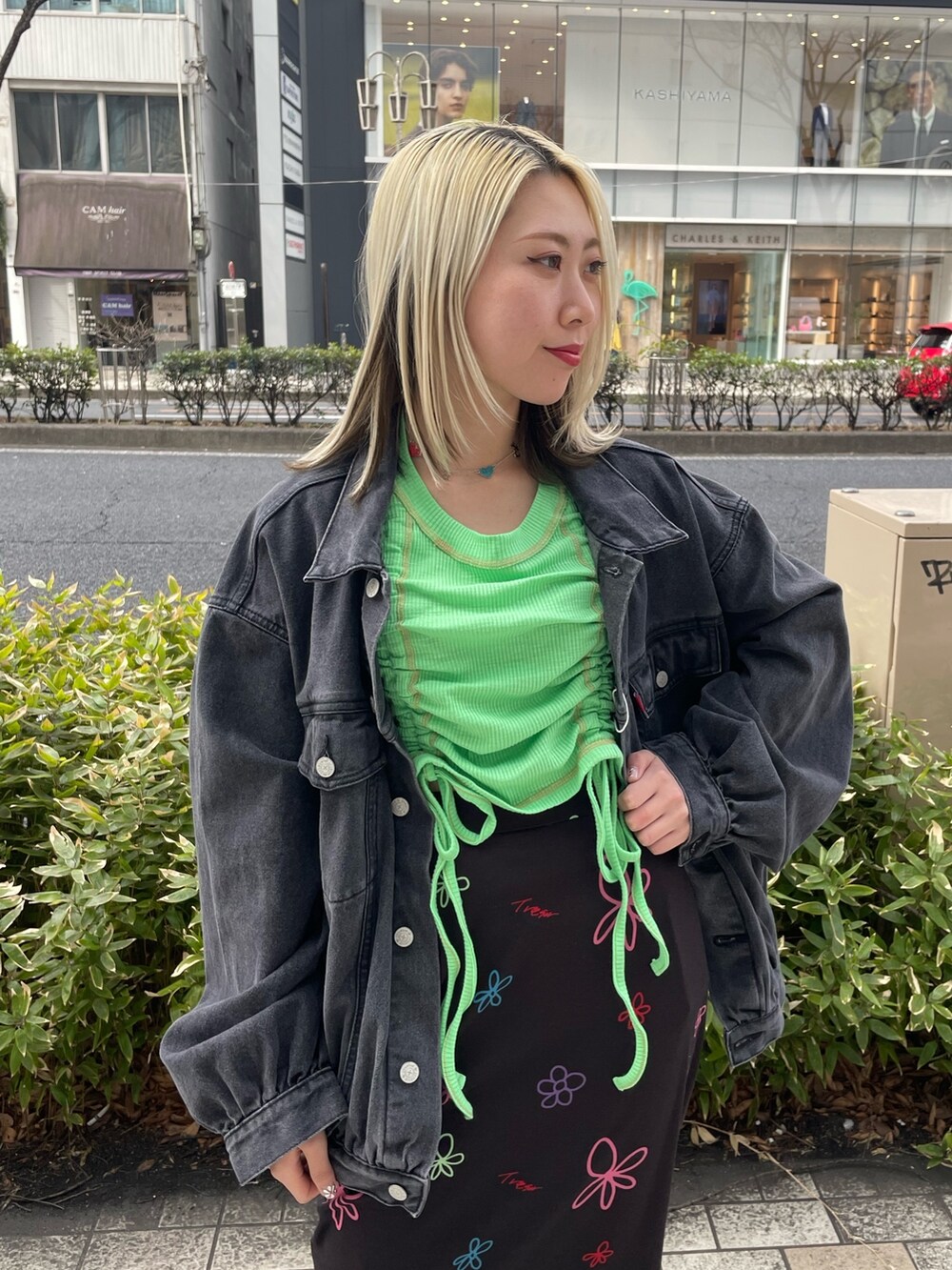 ブラック系のスカート、グリーン系のTシャツ/カットソー、ブラック系のデニムジャケットを着用したレディースの春コーディネートの7枚目の写真