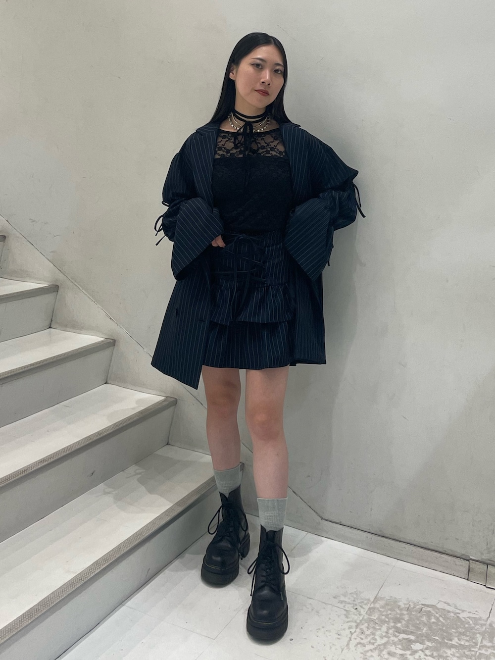 ブラック系のTシャツ/カットソー、ブルー系のテーラードジャケット、ブルー系のスカートを着用したレディースの秋コーディネートの2枚目の写真