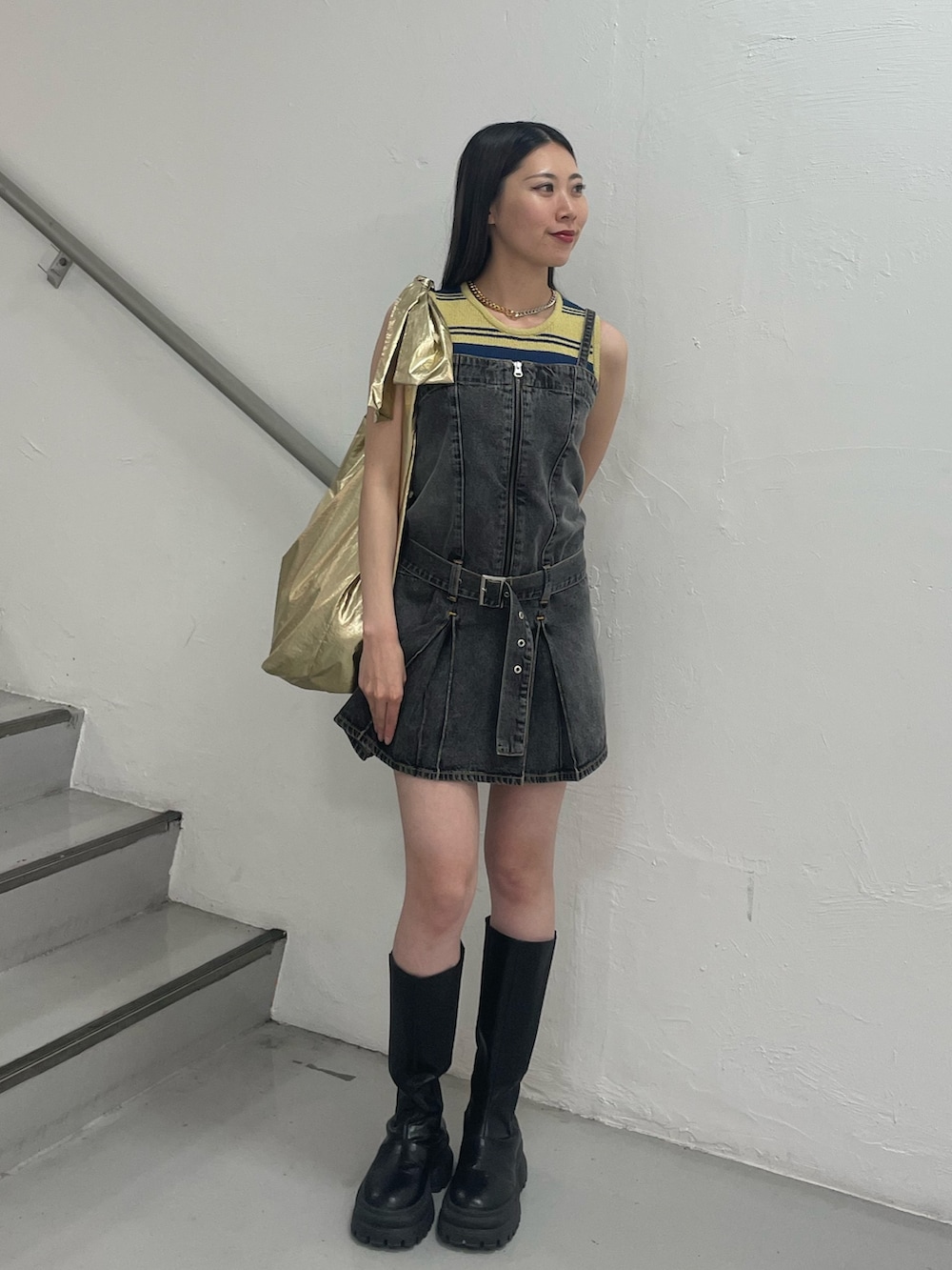 ブラック系のワンピース、イエロー系のタンクトップ、ゴールド系のトートバッグを着用したレディースの夏コーディネートの2枚目の写真