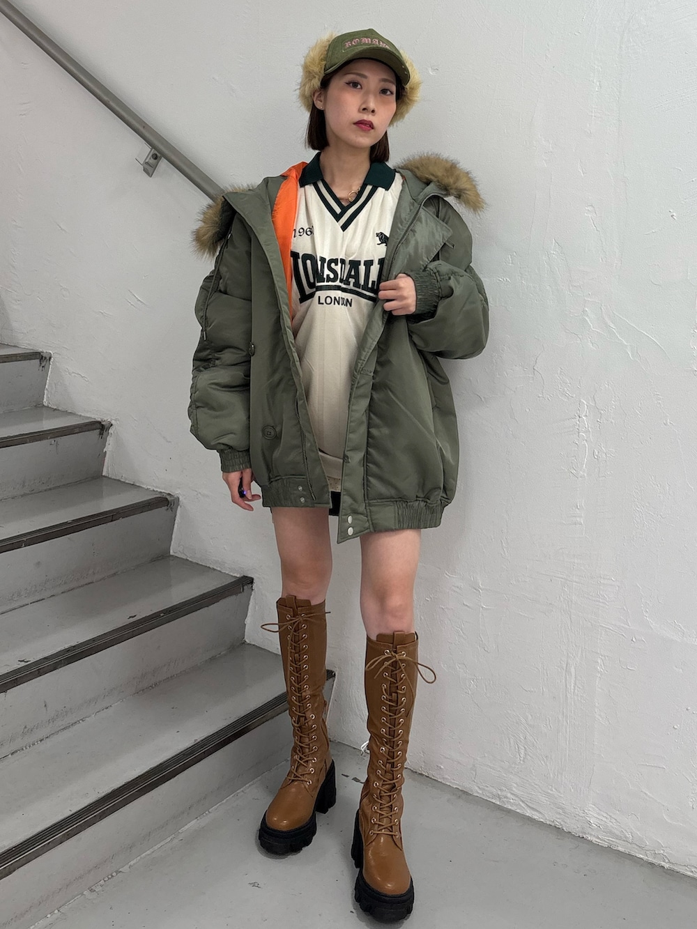 ホワイト系のTシャツ/カットソー、ホワイト系のスカート、グリーン系のブルゾンを着用したレディースの秋コーディネートの3枚目の写真