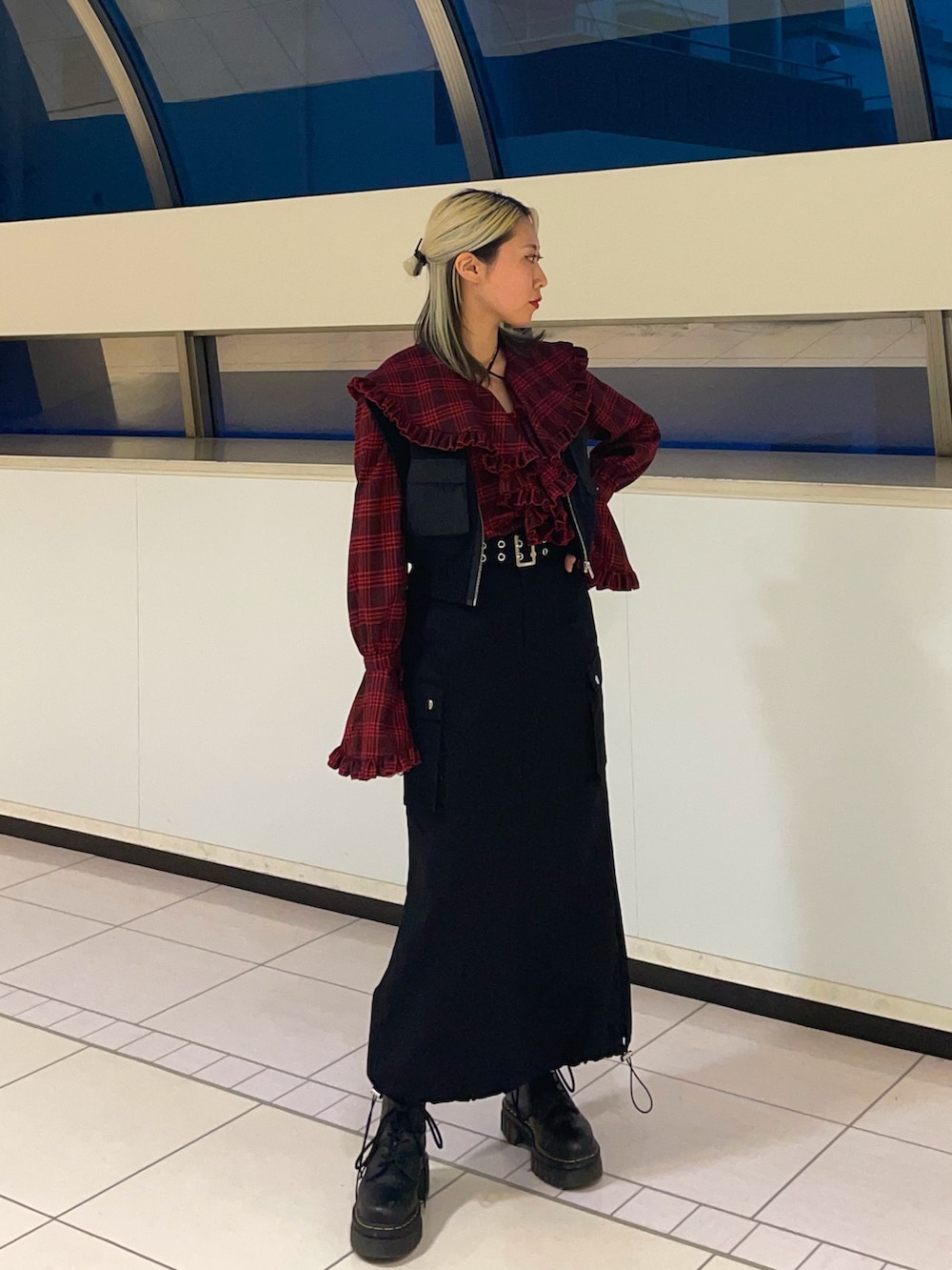 ブラック系のスカート、ブラック系のベスト、レッド系のシャツ/ブラウスを着用したレディースの春コーディネートの2枚目の写真