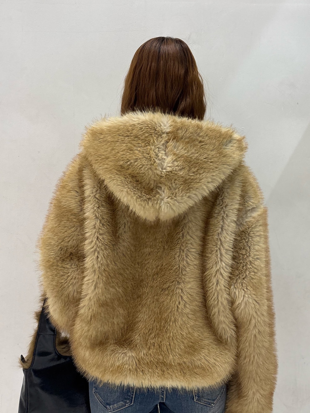 ブルー系のデニムパンツ、ブラック系のハンドバッグ、ブラック系のパンプスを着用したレディースの秋コーディネートの8枚目の写真