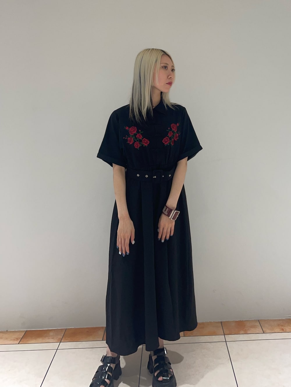 ブラック系のワンピース、ブラック系のサンダル、レッド系のブレスレットを着用したレディースの夏コーディネートの3枚目の写真