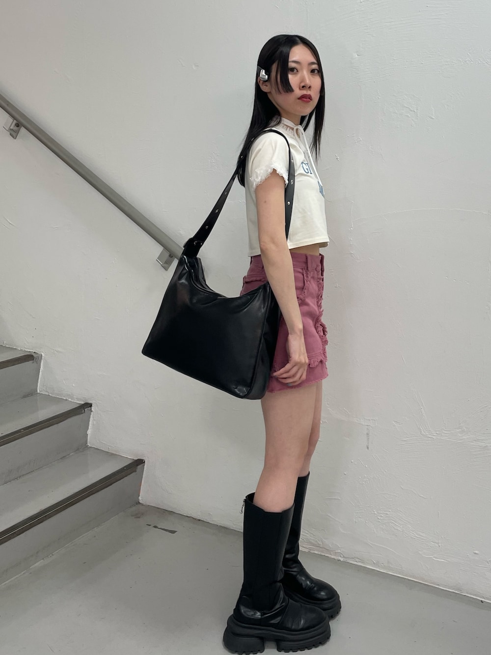 ピンク系のスカート、ホワイト系のTシャツ/カットソー、ブラック系のショルダーバッグを着用したレディースの春コーディネートの3枚目の写真