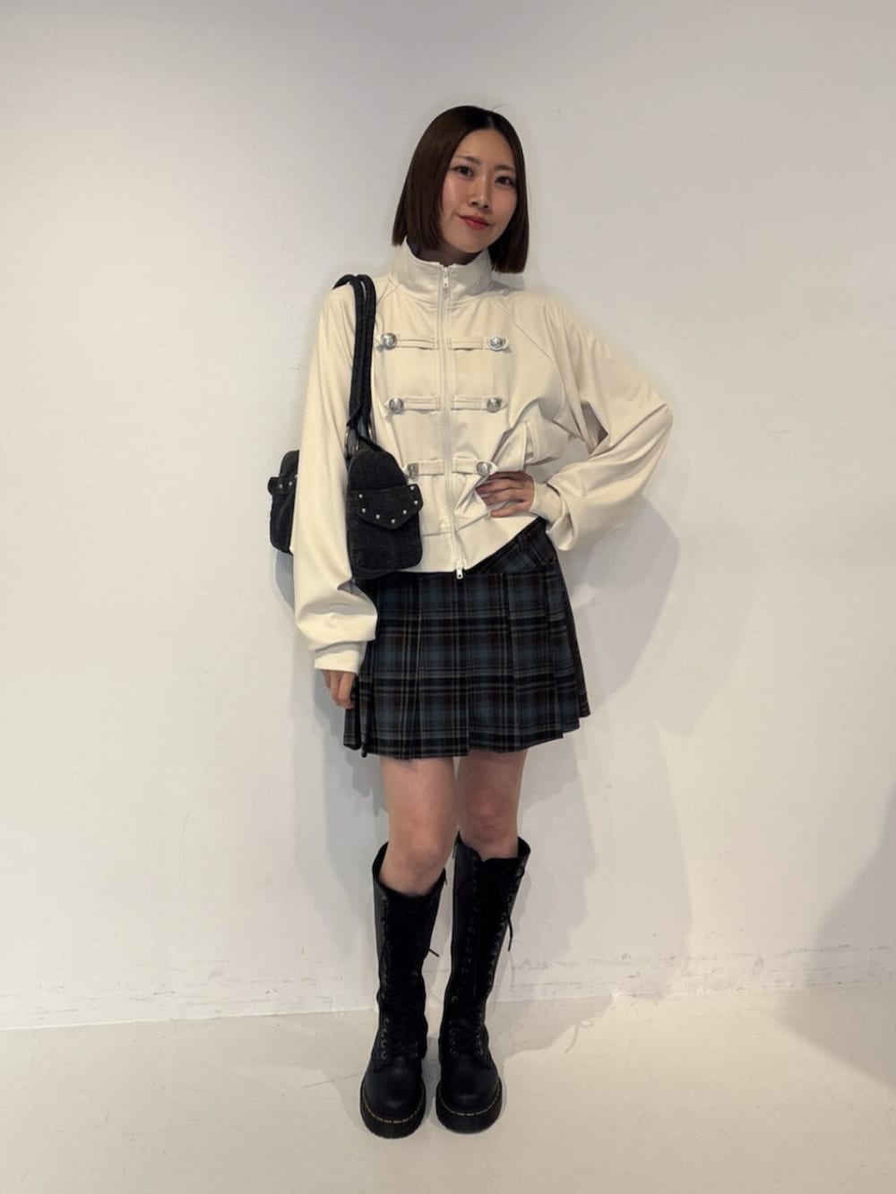 ブラック系のボストンバッグ、ホワイト系のTシャツ/カットソー、ブルー系のスカートを着用したレディースの夏コーディネートの2枚目の写真