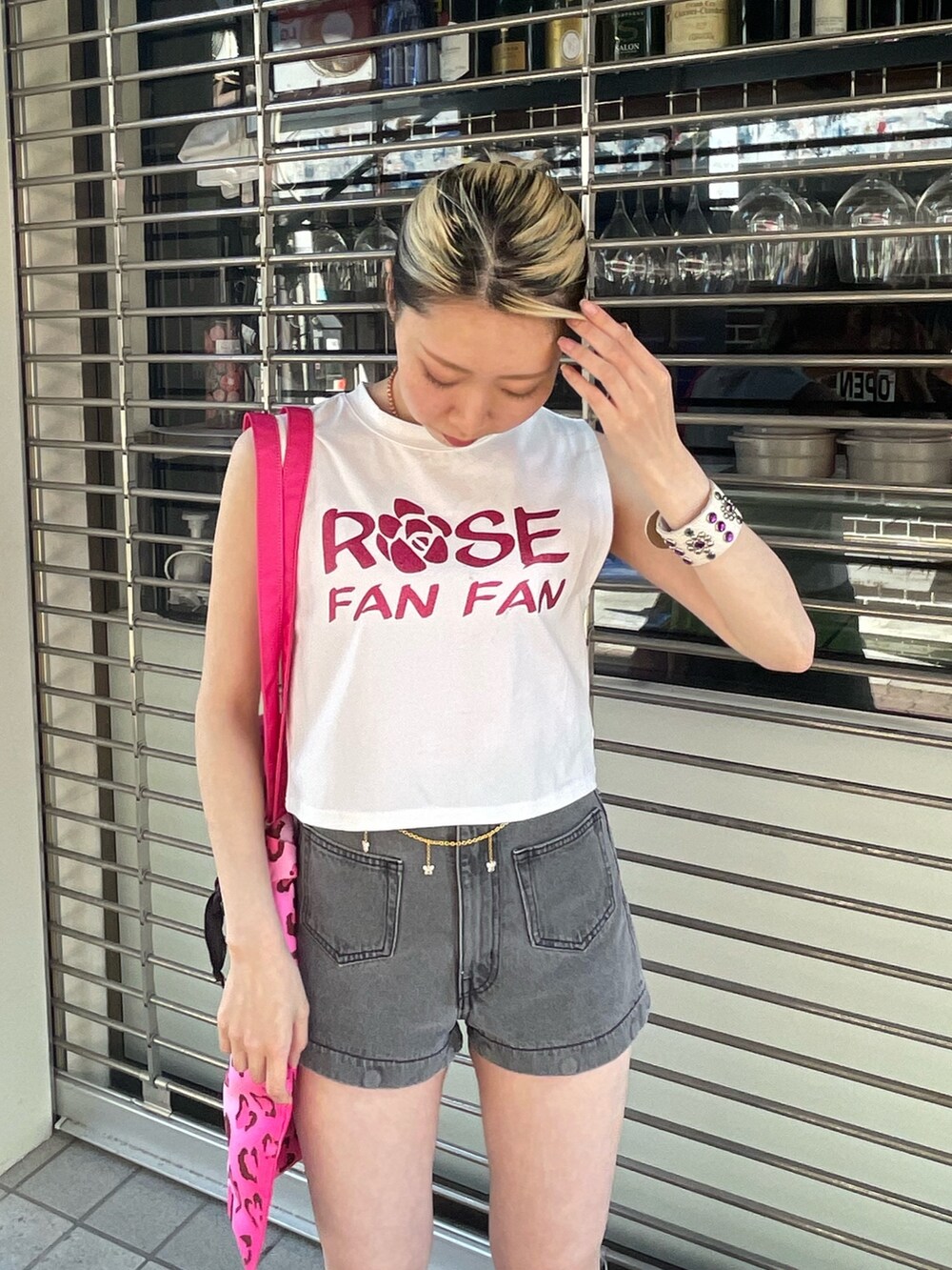 ホワイト系のタンクトップ、ブラック系のデニムパンツ、ピンク系のトートバッグを着用したレディースの春コーディネートの5枚目の写真