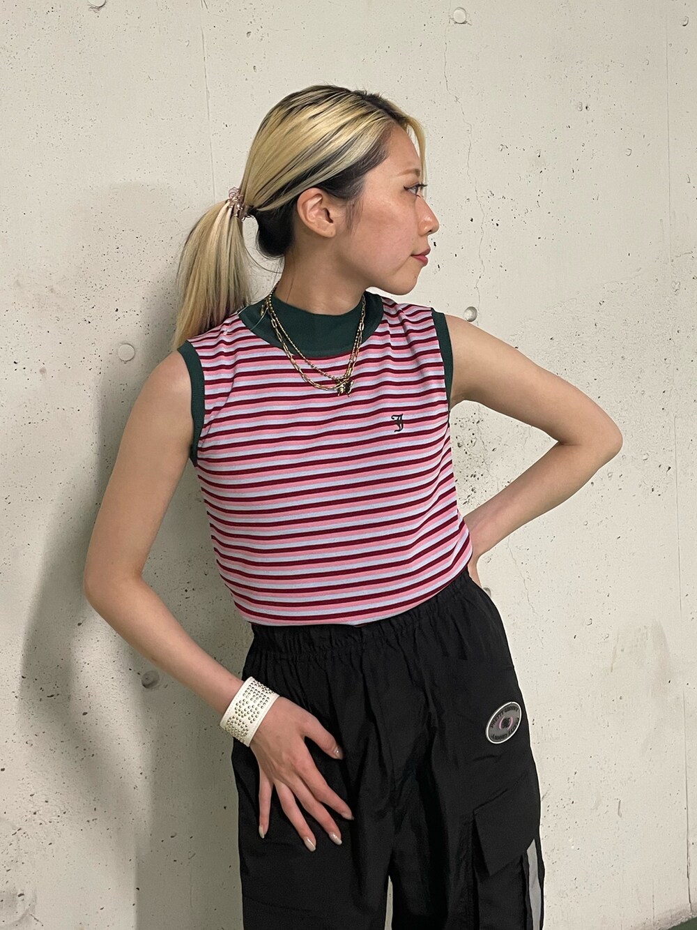 ブラック系のカーゴパンツ、ピンク系のニット/セーター、ホワイト系のブレスレットを着用したレディースの夏コーディネートの6枚目の写真