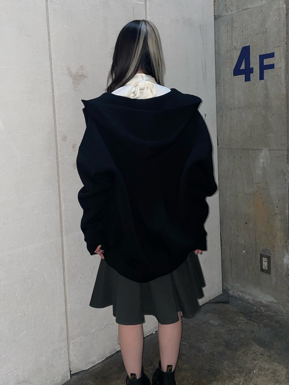 ブラック系のスカート、ブラック系のパーカー、ホワイト系のシャツ/ブラウスを着用したレディースの冬コーディネートの3枚目の写真