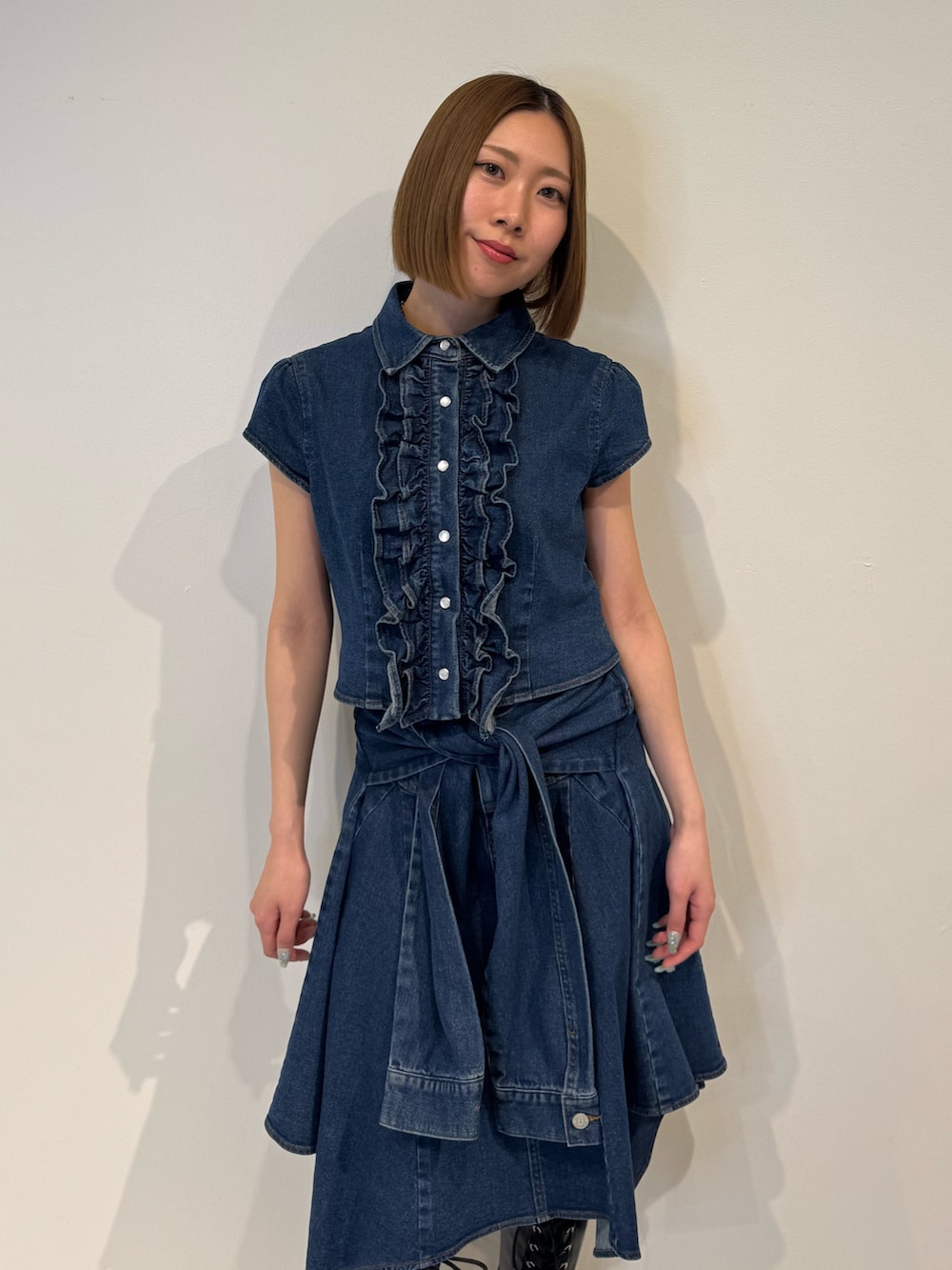 ブルー系のシャツ/ブラウス、ブルー系のスカート、ブラック系のブーツを着用したレディースの春コーディネートの5枚目の写真